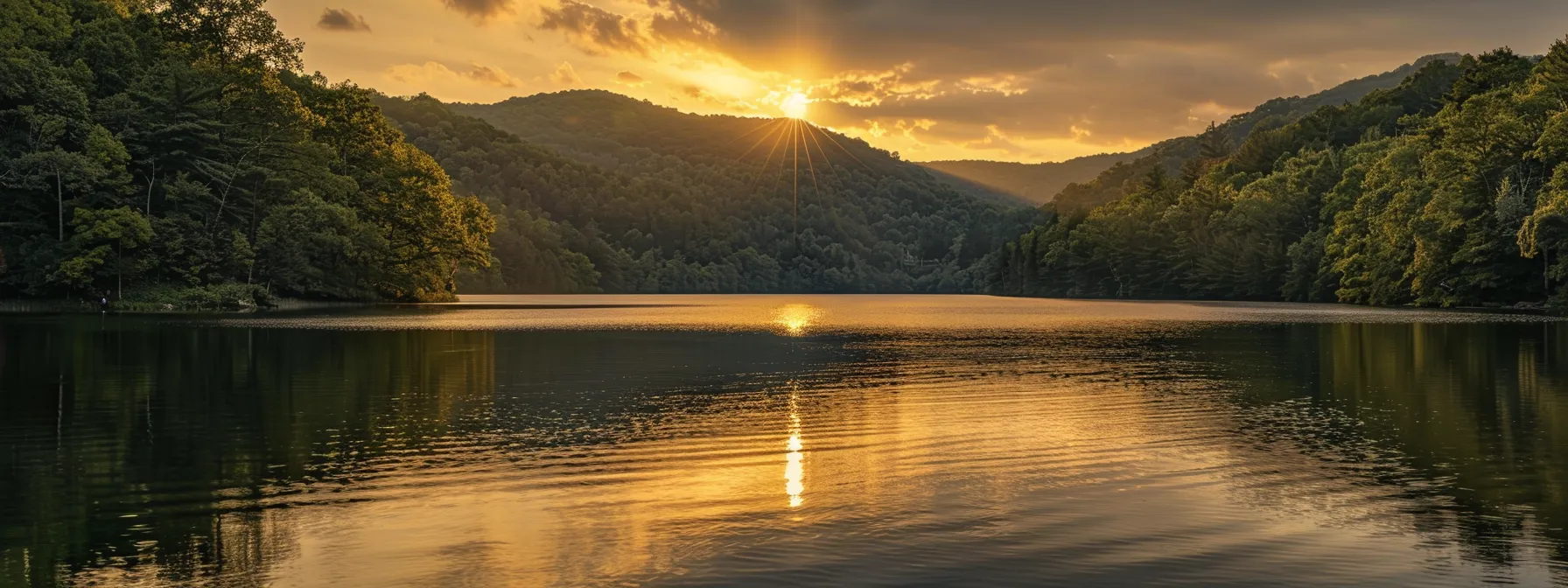 a breathtaking sunset casts a warm golden glow over a serene lake, surrounded by towering, lush green mountains that reflect perfectly on the water's glassy surface.